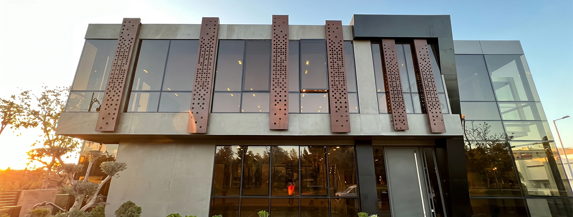 Panneau mural en acier Corten avec motif d’arbre découpé, utilisé comme claustra décoratif dans un espace chaleureux.