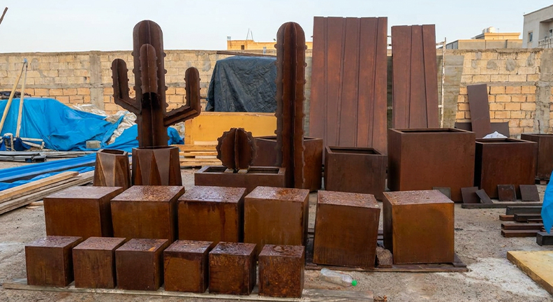 Ensemble de jardinières carrées et rectangulaires en acier Corten fabriquées sur mesure dans un atelier au Maroc.