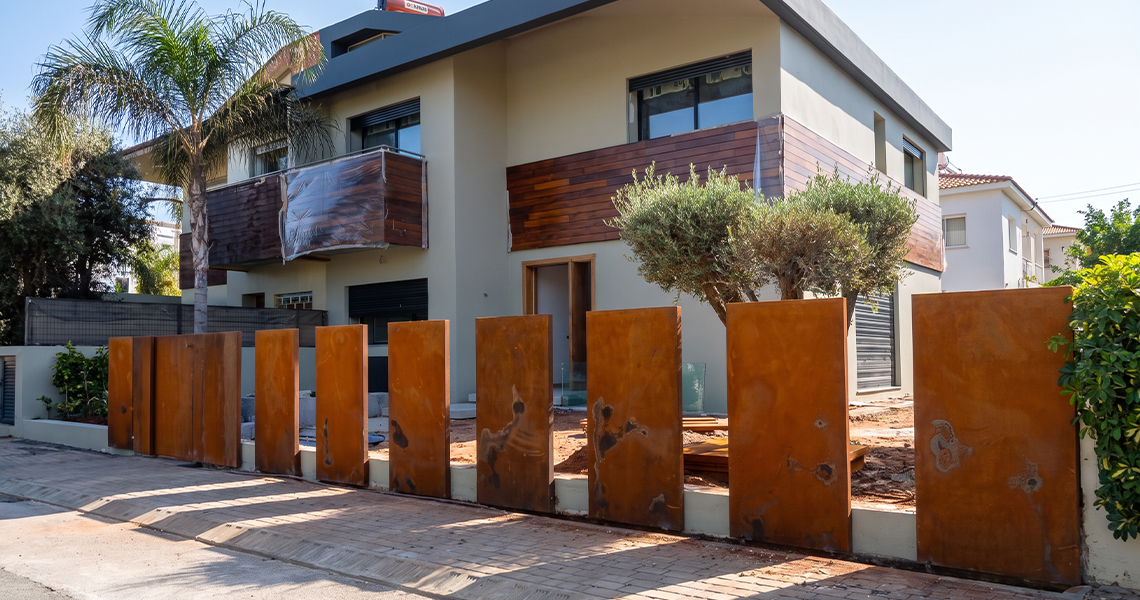 Panneaux verticaux en acier Corten installés devant une villa contemporaine pour créer un habillage extérieur architectural sur mesure.