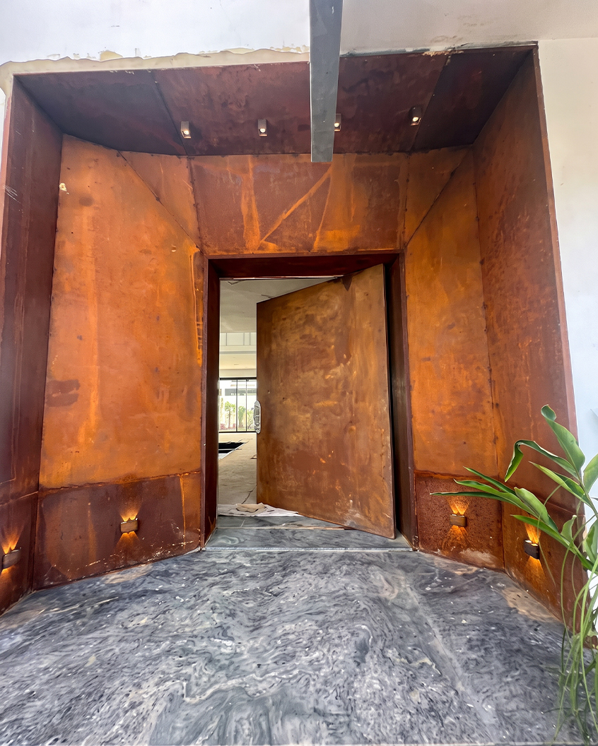 Entrée monumentale de la Villa Émeraude à Casablanca, habillée de panneaux et d’une porte sur mesure en acier Corten.