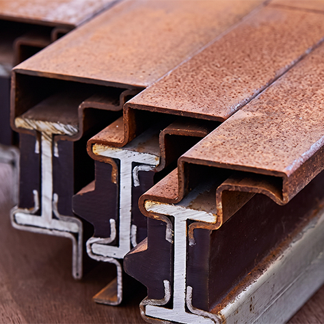 Détail de profilés métalliques présentant différentes finitions et une patine protectrice en acier Corten pour mobilier extérieur durable.